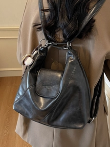 Retro black leather tote bag with magnetic flap and baseball pendant shown on model