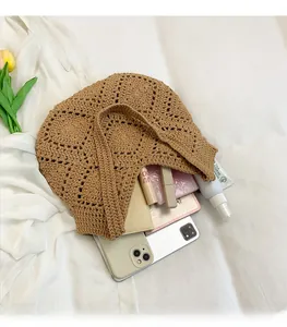 Vue détaillée de l'intérieur spacieux d'un sac fourre-tout en crochet kaki avec objets