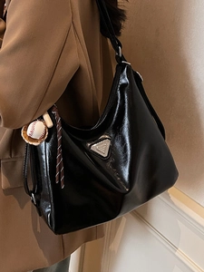 Glänzende schwarze Vintage Hobo-Tasche mit Logo und Baseball-Anhänger