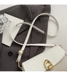 Detail of white leather and woven fabric shoulder bag with gold horseshoe buckle closure