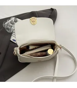 Internal capacity of the white saddle bag showing phone, wallet and cosmetics inside