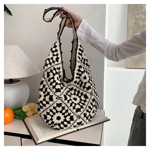 Detailed close-up of a handmade crochet tote bag featuring black and white floral patterns