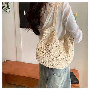 Détail du sac cabas en crochet crème présentant des textures de tricot fleuries ajourées