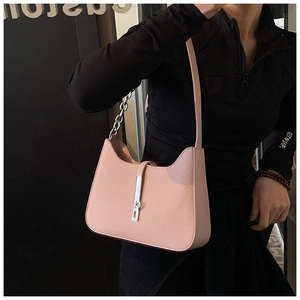 Detail shot of a light pink woven shoulder bag featuring a silver metal buckle and chain strap