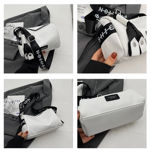 Macro shot of white Boston bag with litchi grain leather and branded fashion strap
