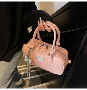Detailed view of pink bowling bag with silver metallic bow charm and top handle