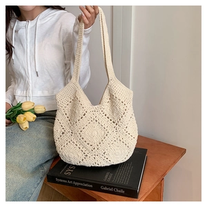 Gros plan sur un sac hobo au crochet beige avec des motifs ajourés pour un look boho