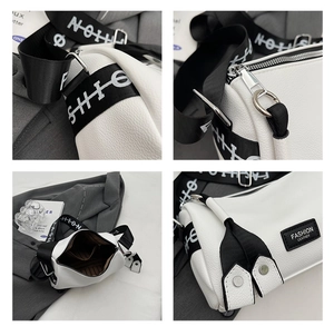 Detail view of white leather cylinder crossbody bag with wide fashion strap and metal hardware