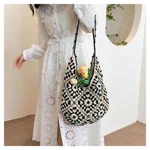 Detail of the crochet granny square pattern on a black and white woven tote bag