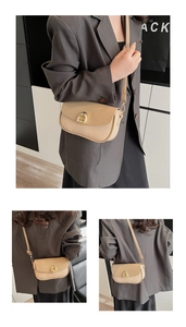 Detail of beige saddle bag featuring smooth leather flap and woven texture with gold buckle
