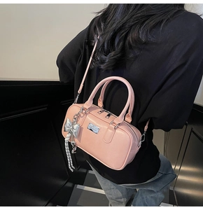 Macro shot of pink leather bowling bag with silver logo tag and cute bow charm detail