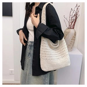 Dettaglio della trama a maglia traforata su una grande borsa tote color crema beige