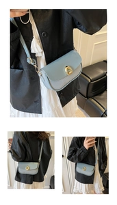 Detail of light blue square bag with woven texture and gold horseshoe buckle