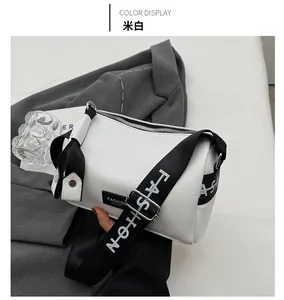 Detail view of off-white pillow bag with fashion letter wide strap on grey suit