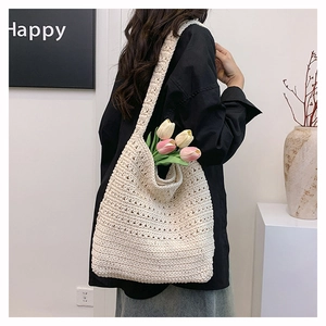 Dettaglio della borsa tote beige all'uncinetto con trama traforata e stile boho