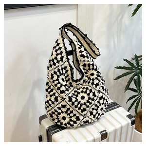 Close-up of crochet floral pattern on a black and white hand-woven tote bag
