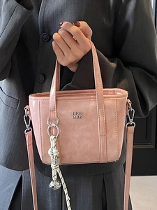 Pink glossy leather bucket bag with metal letters and woven charm for women commute