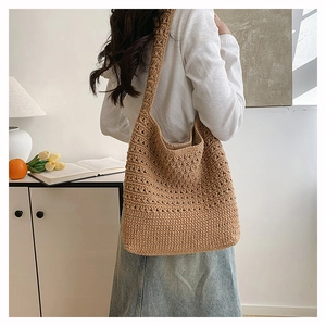 Foto lifestyle di una borsa tote in maglia intrecciata a mano con tracolla larga
