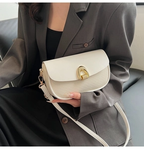 Detail of Korean style woven crossbody bag with white leather flap and golden horseshoe buckle