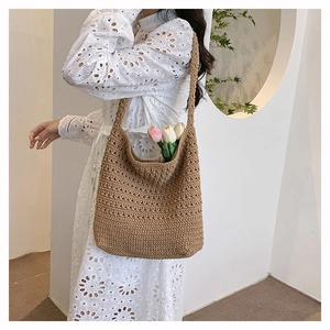 Dettaglio della borsa tote all'uncinetto color kaki con motivo floreale traforato