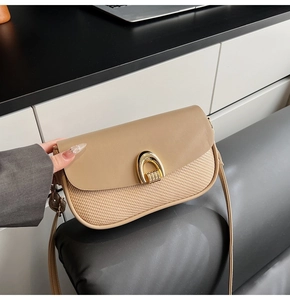 Close-up of khaki leather and woven texture mix bag with golden horseshoe clasp