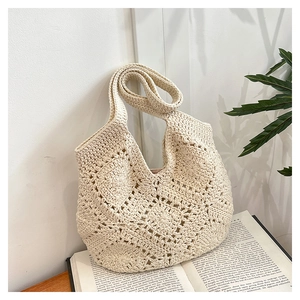 Gros plan d'un sac cabas en crochet beige aux motifs floraux ajourés et texture tissée