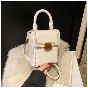 Detailed view of white PU leather box bag with gold buckle and rivet edge decoration