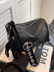 Minimalist black lychee leather crossbody pillow bag with wide FASHION lettering strap