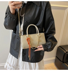 Détail du sac à main crème en cuir ciré avec chaîne dorée et cordon tressé déco