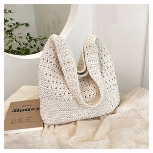 Dettaglio ravvicinato della borsa tote beige intrecciata con trama morbida in maglia traforata
