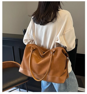 Detailed back view of a large brown matte leather tote bag with adjustable shoulder strap