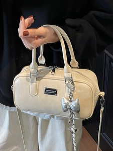 Creamy white bowling handbag in glossy leather with a silver bow charm for women