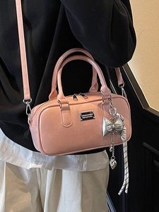 Chic pink bowling bag in shiny leather with heart charm and detachable shoulder strap