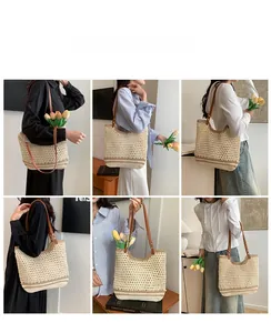 Detail view showing beige woven straw tote bag with brown leather straps and metal rivets