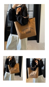 Detail of camel tote bag featuring MDL logo print and premium leather handles