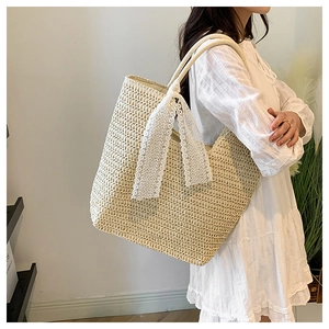Detailed close-up of a large beige woven tote bag with white lace bow on the handle