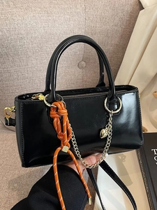 Petit sac à main noir en cuir ciré avec nœud de corde orange et breloque de cœur