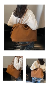 Detailed macro view of the brown matte suede texture and adjustable strap on the tote bag