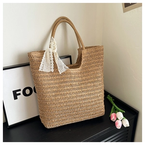 Detailed texture of handwoven straw tote bag with elegant white lace ribbon handle