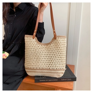 Detail of woven beach tote with leather handles and metallic rivet reinforcement