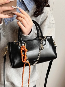 Petit sac à main noir en cuir ciré avec nœud de corde orange et chaîne en cœur dorée