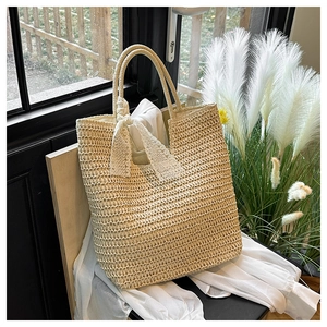 Detailed close-up of beige woven bag texture featuring a delicate white lace bow detail