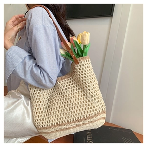 Detail of crochet woven tote bag with brown leather strap and hollow textured pattern