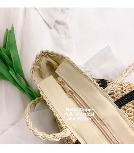 Close-up of woven tote bag featuring golden hardware zipper and beige straw material texture