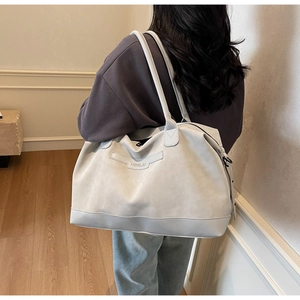 Detail shot of the large grey tote bag on model showing size and soft suede texture