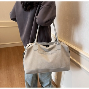 Detail showing the light grey suede texture and NINGJIA embossed leather logo strap