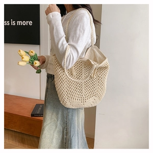 Close-up of cream crochet tote bag with large mesh pattern and tassel drawstring detail