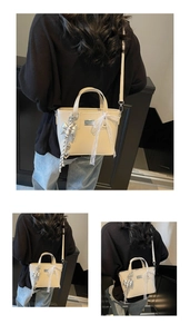 Detail of cream oil wax leather bucket bag with silver bow charm and lace ribbon