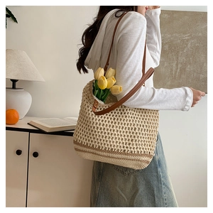 Detail of beige crochet tote bag with leather straps on a model in a minimal setting