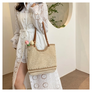 Detail of woven mesh tote bag featuring brown leather handles and interior tulip decor